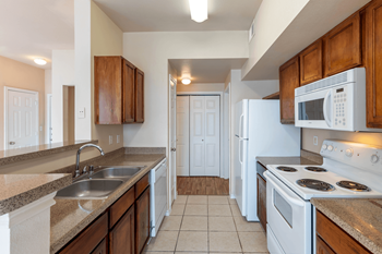 a kitchen with white appliances and brown cabinets